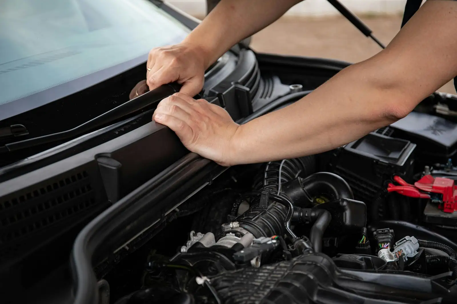 Person inspecting car engine components