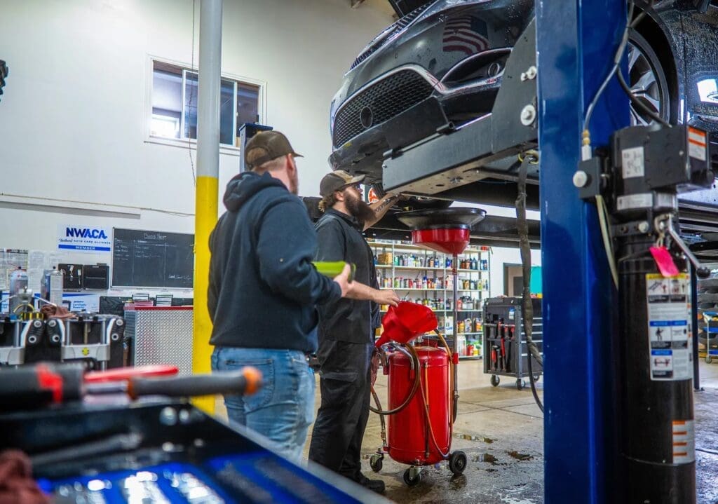 Mechanics working on a car lift.
